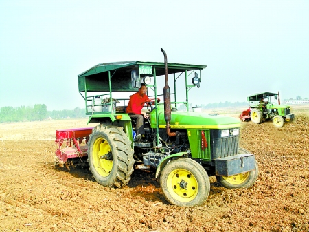 麦收过后,淅川县厚坡镇卢咀村农民正在用大型旋耕机抢种玉米(6月6日摄