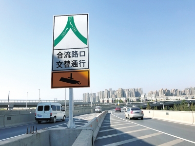 突然出现了一种新型的道路标志牌,上面写着"合流路口交替通行"八个大